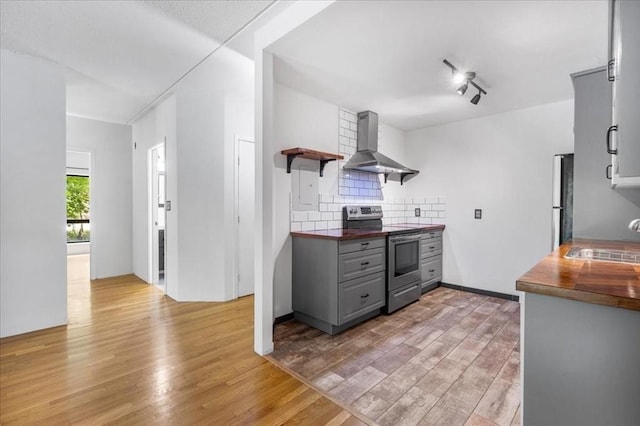 14 Heron St Unit 209, Boston, MA 02132 - kitchen with stainless steel range with electric stovetop, wall chimney range hood, gray cabinetry, open shelves, and light wood-type flooring