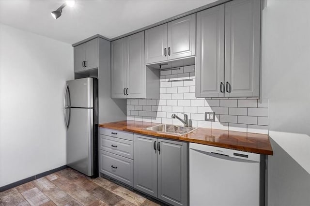 14 Heron St Unit 209, Boston, MA 02132 - kitchen featuring white dishwasher, freestanding refrigerator, gray cabinetry, decorative backsplash, and wood finished floors