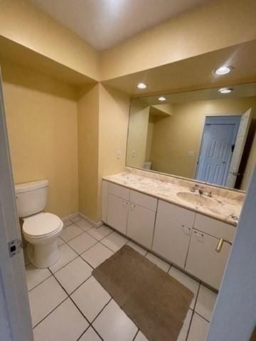 bathroom with toilet, vanity, and tile patterned floors