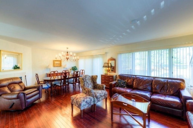 living room with dark wood-type flooring and a notable chandelier