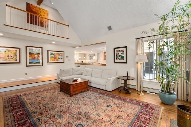 living room with hardwood / wood-style flooring, a baseboard radiator, and high vaulted ceiling