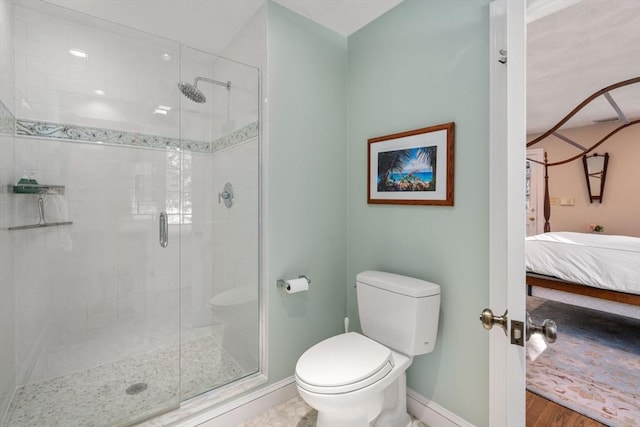 bathroom featuring toilet and a shower with door