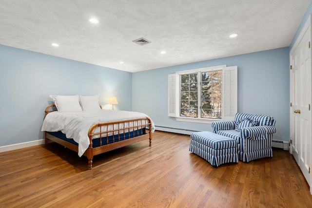 bedroom featuring hardwood / wood-style flooring and a baseboard radiator