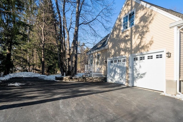 view of snowy exterior featuring a garage