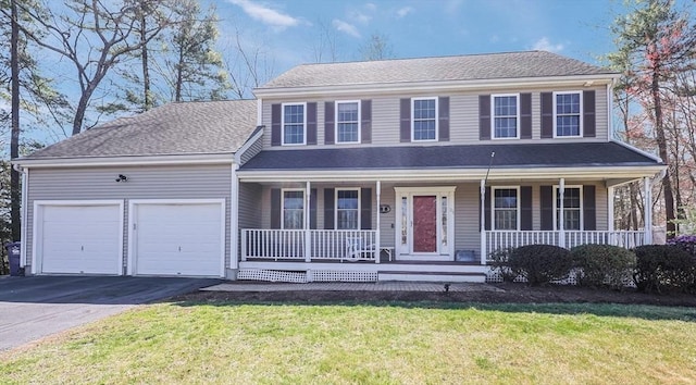 colonial home featuring covered porch, an attached garage, driveway, and a front yard