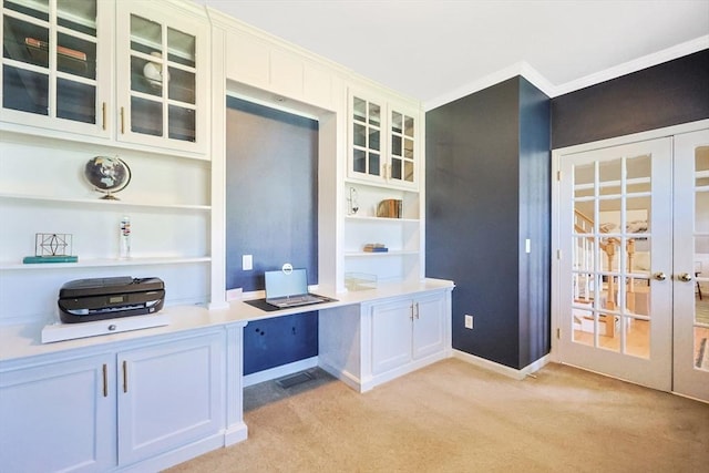unfurnished office featuring built in study area, baseboards, light carpet, and french doors