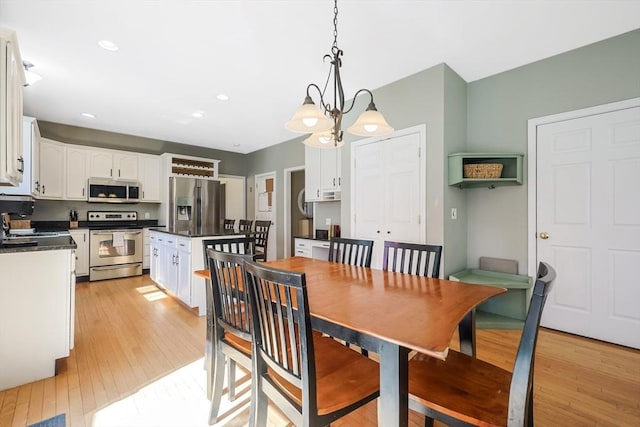 dining area with recessed lighting, an inviting chandelier, and light wood finished floors