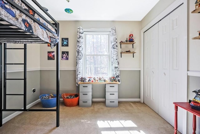 carpeted bedroom featuring baseboards and a closet