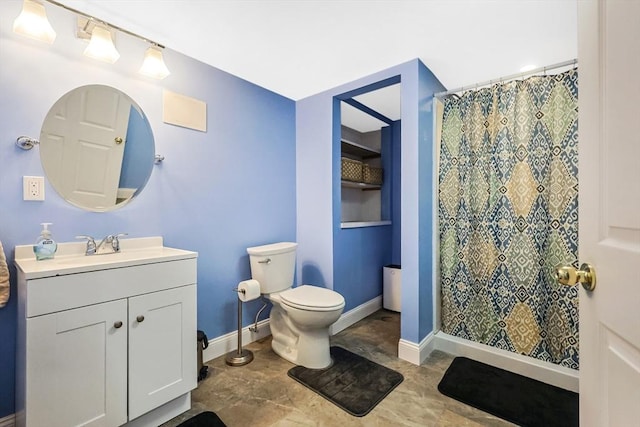 bathroom featuring a shower with curtain, baseboards, vanity, and toilet
