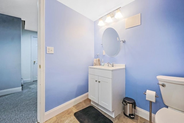 bathroom featuring baseboards, toilet, and vanity