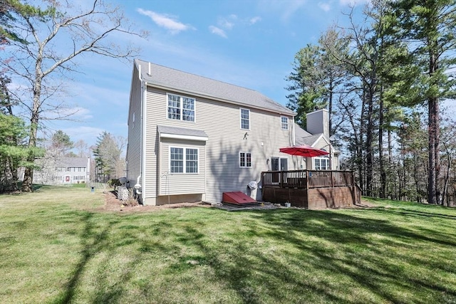rear view of house featuring a wooden deck, a yard, and a chimney