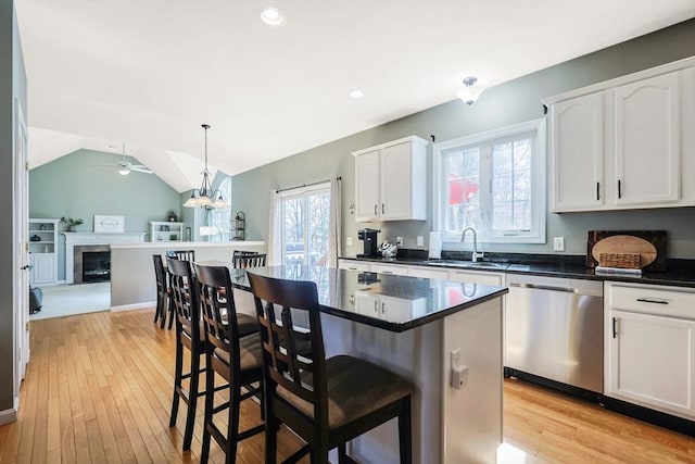 kitchen featuring a sink, dark countertops, stainless steel dishwasher, and a ceiling fan