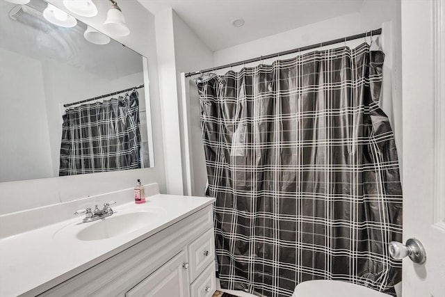 bathroom with walk in shower, vanity, and toilet