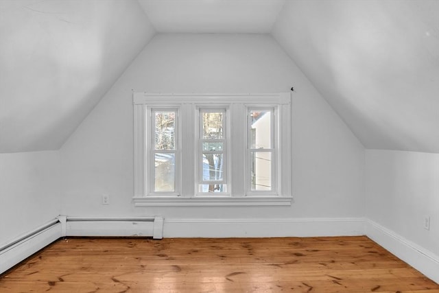 additional living space featuring lofted ceiling, light wood-type flooring, and baseboard heating