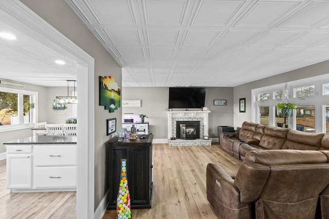 living room featuring a brick fireplace and light hardwood / wood-style flooring