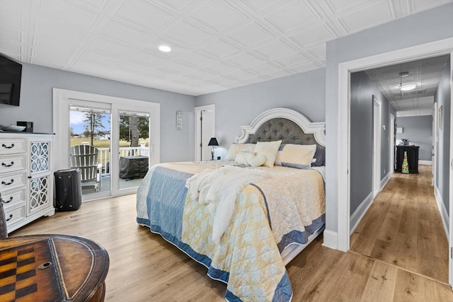 bedroom featuring access to exterior and light hardwood / wood-style flooring