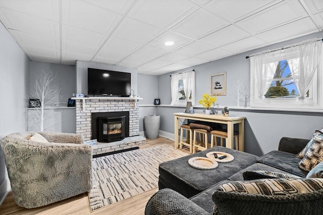 living room with hardwood / wood-style floors, a healthy amount of sunlight, and a brick fireplace