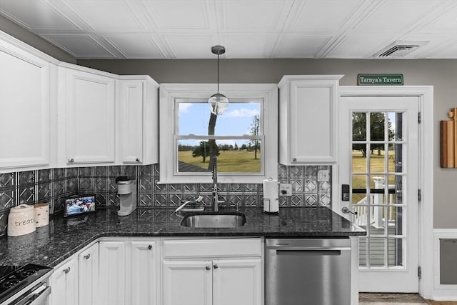 kitchen featuring sink, dark stone countertops, pendant lighting, stainless steel appliances, and white cabinets