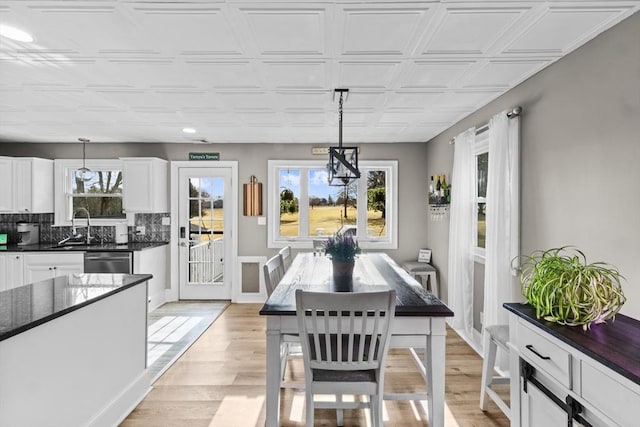 dining space featuring sink, a wealth of natural light, and light hardwood / wood-style floors