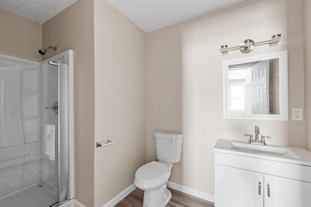 full bath featuring baseboards, toilet, a stall shower, wood finished floors, and vanity