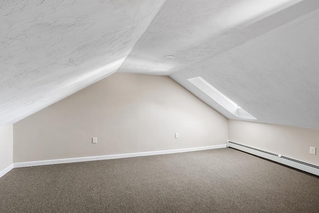 bonus room with baseboards, lofted ceiling with skylight, carpet floors, baseboard heating, and a textured ceiling