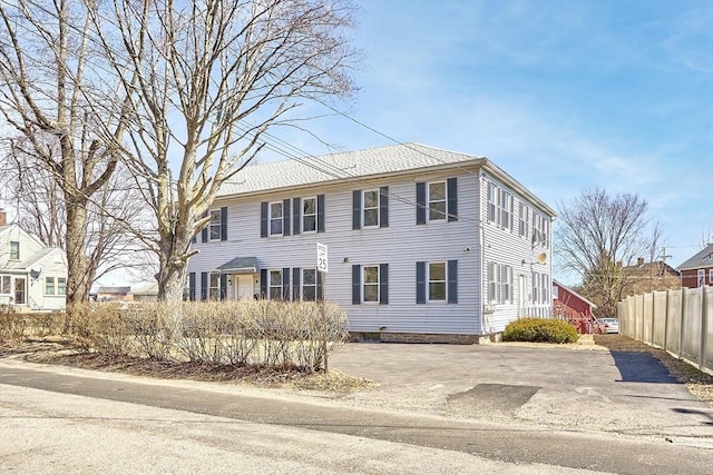 colonial-style house featuring fence