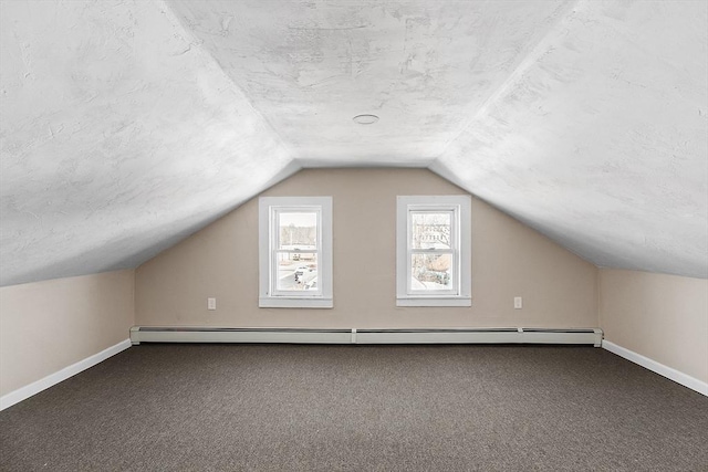 bonus room with a baseboard heating unit, carpet floors, and a textured ceiling