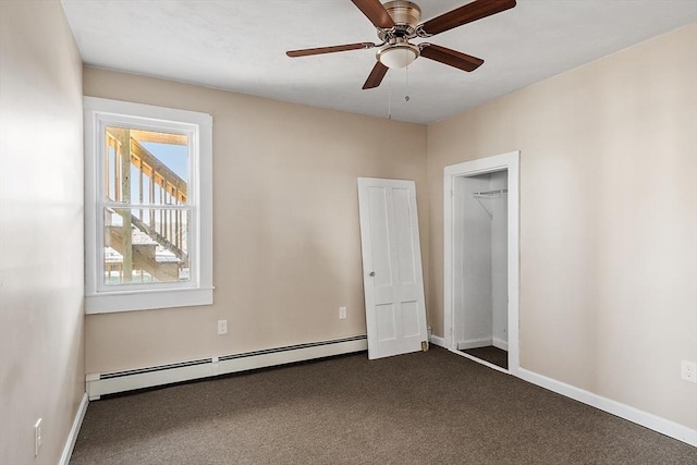 unfurnished room featuring a baseboard radiator, baseboards, a ceiling fan, and dark carpet