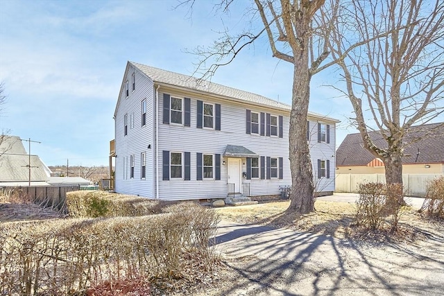 colonial house featuring entry steps and fence