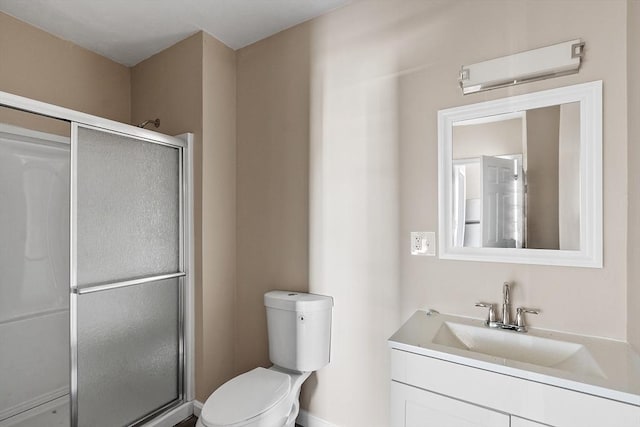 bathroom featuring a shower stall, toilet, and vanity