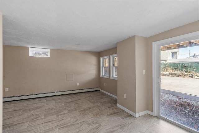 spare room featuring baseboard heating and baseboards