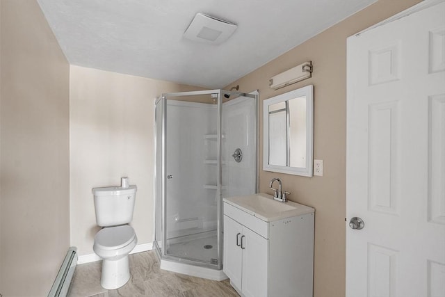 full bath featuring vanity, baseboards, a shower stall, toilet, and baseboard heating