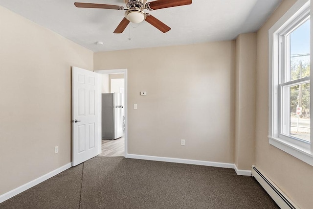 carpeted empty room with a wealth of natural light, baseboards, and baseboard heating