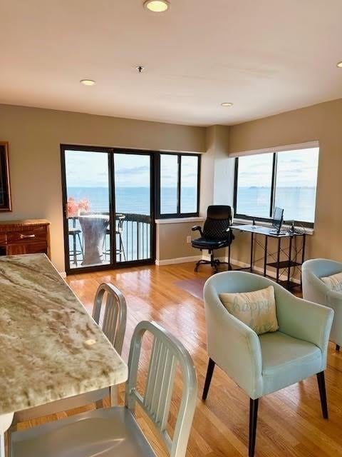 living room featuring a water view and light hardwood / wood-style flooring