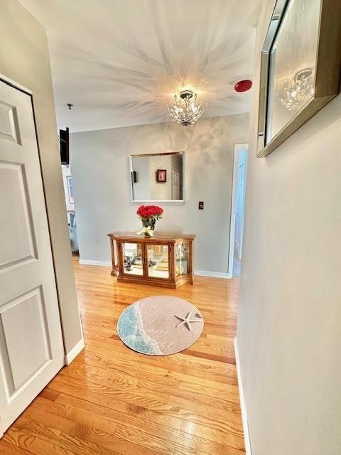 corridor featuring light hardwood / wood-style flooring and a chandelier