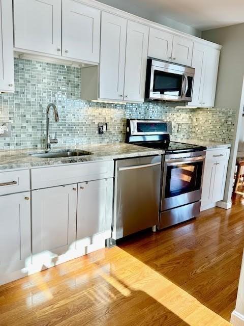 kitchen featuring white cabinets, sink, stainless steel appliances, and tasteful backsplash