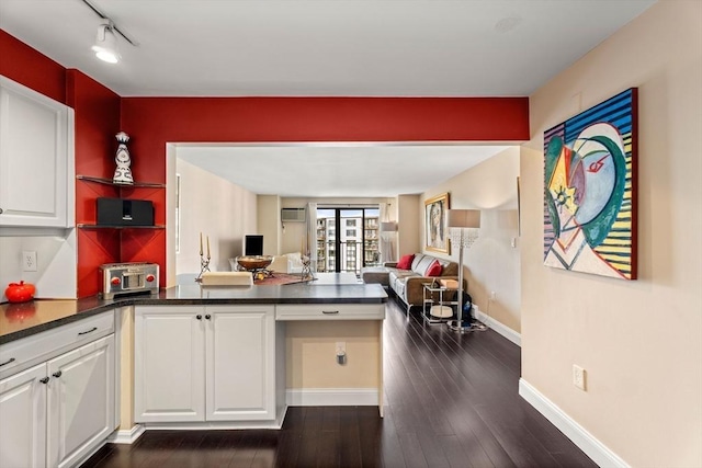 131 Coolidge Ave Unit 621, Watertown, MA 02472 - kitchen with dark countertops, open floor plan, a peninsula, white cabinets, and dark wood-type flooring