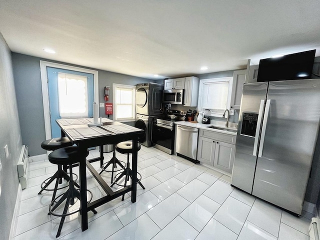 27 Overlook Rd, Holbrook, MA 02343 - kitchen featuring appliances with stainless steel finishes, stacked washer / dryer, a sink, baseboard heating, and light countertops