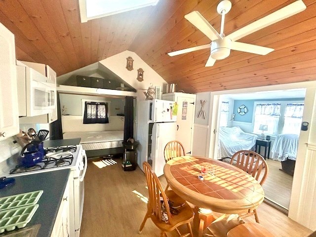 kitchen featuring white cabinetry, lofted ceiling, light hardwood / wood-style flooring, and white appliances