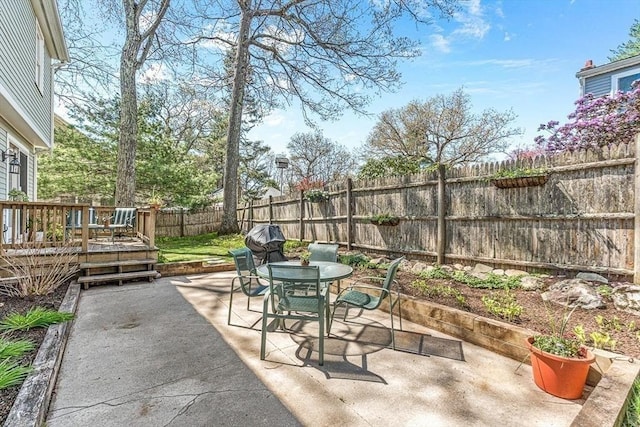 view of patio / terrace with a fenced backyard, a wooden deck, and outdoor dining area