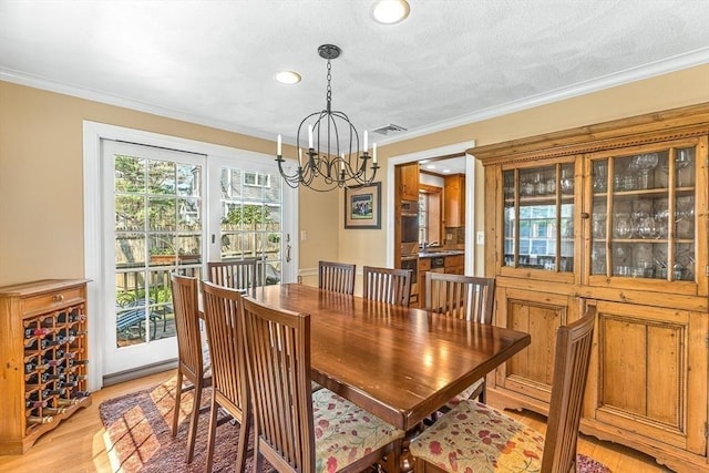dining space featuring visible vents, crown molding, a chandelier, recessed lighting, and light wood-style flooring