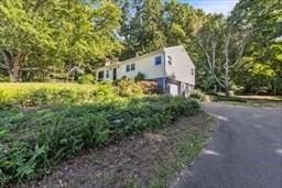 view of home's exterior featuring an attached garage and aphalt driveway