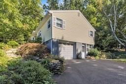 view of property exterior with driveway and a garage