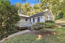 view of front of home featuring a wooden deck and a front lawn