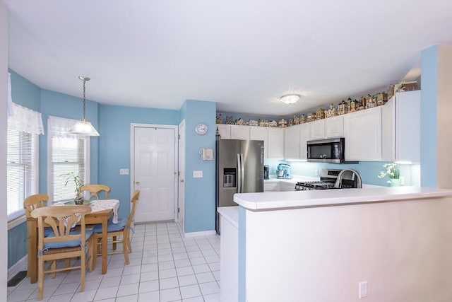 kitchen featuring light tile patterned flooring, stainless steel appliances, light countertops, baseboards, and white cabinetry