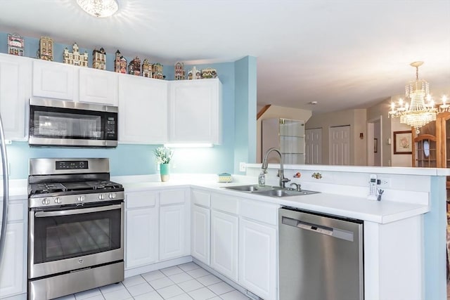 kitchen featuring white cabinets, a peninsula, a sink, light countertops, and appliances with stainless steel finishes