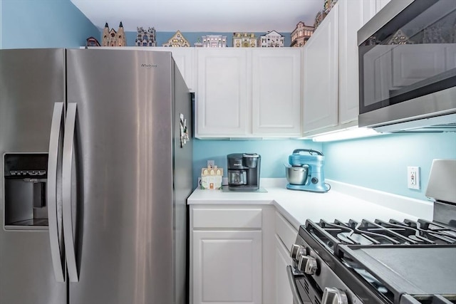 kitchen featuring stainless steel appliances, light countertops, and white cabinetry