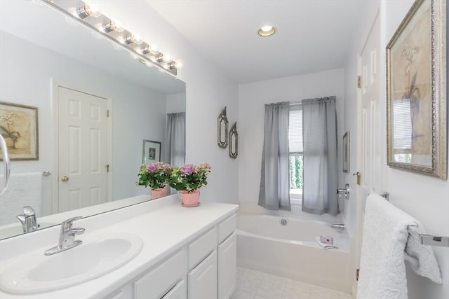 bathroom featuring a garden tub, vanity, and recessed lighting