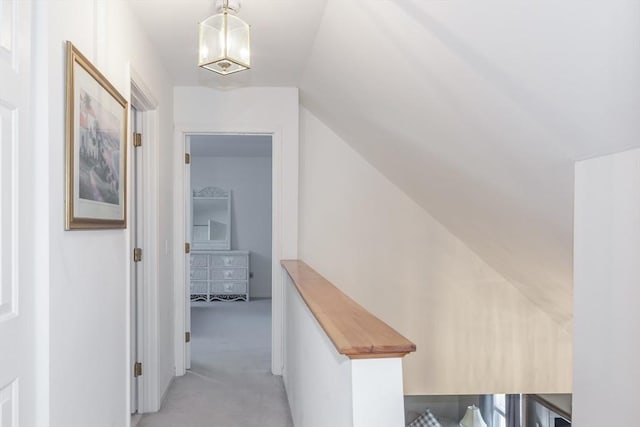 hall featuring lofted ceiling and light colored carpet