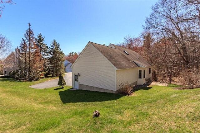 view of side of home with a yard